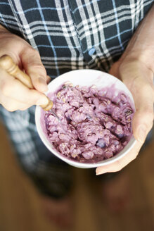 Mann im Pyjama isst Müsli mit Sojajoghurt, Blaubeeren und Banane - HAWF000545