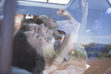 South Africa, Friends on a road trip lying in car boot - ZEF002682