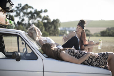 Südafrika, Freunde auf einer Autoreise, die sich auf der Motorhaube ausruhen - ZEF002701