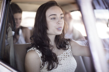 South Africa, Friends on road trip driving in car chewing bubble gum - ZEF002723