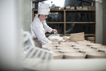 Bäckerin bereitet Keramikschalen zum Brotbacken vor - ZEF003784