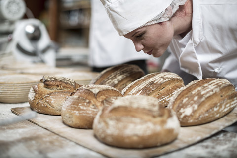 Female baker smelling fresh bread stock photo