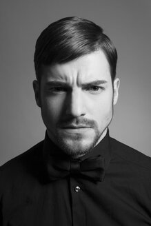 Portrait of serious looking man wearing black bow and black shirt - SHKF000103