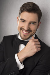 Portrait of smiling man wearing dinner jacket and bow - SHKF000105