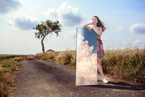 Teenage girl with mirror in rural landscape stock photo