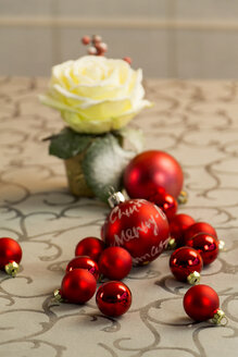 Weihnachtsdekoration mit roten Christbaumkugeln und Rosenblüten - JUNF000160