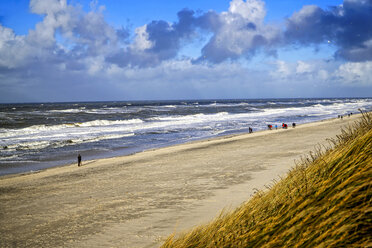 Deutschland, Sylt, Westerland, Spaziergänger am Strand im Winter - HOHF001259