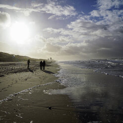 Deutschland, Sylt, Westerland, Spaziergänger am Strand im Winter bei Ebbe - HOHF001261