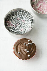 Cupcake mit Schokoladen- und Zuckerperlen und Schalen mit Zuckerperlen - MYF000794