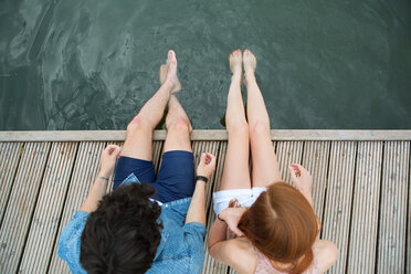 Elevated view of young couple sitting on jetty - WESTF020689