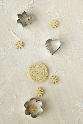 Home-baked birthday cookies and metal cookie cutters on light wood stock photo