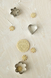 Home-baked birthday cookies and metal cookie cutters on light wood - MYF000798
