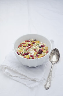 Schale mit hausgemachtem Müsli mit Cerealien, Beeren, Quinoa-Körnern und Kokosflocken auf weißem Tuch - CZF000187