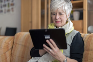 Ältere Frau mit digitalem Tablet auf dem Sofa - FRF000168