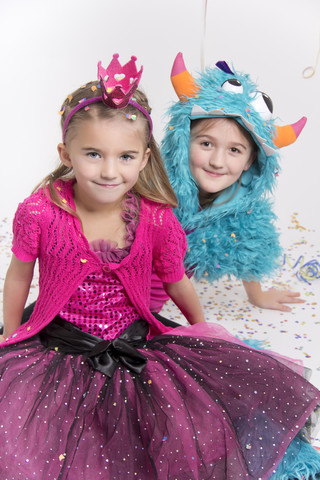 Two smiling girls masquerade as a princess and monster stock photo