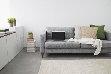 Geöffneter Laptop auf der Couch im modernen Wohnzimmer - PDF000656