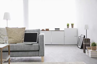 Geöffneter Laptop auf der Couch im modernen Wohnzimmer - PDF000668