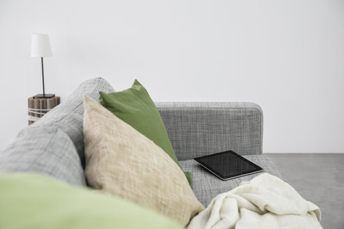 Digitales Tablet auf der Couch in einem modernen Wohnzimmer liegend - PDF000672