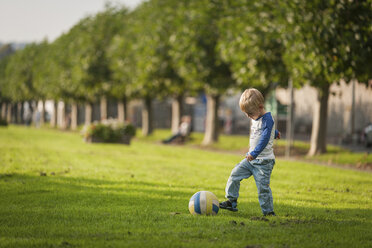 Junge spielt Fußball auf der Wiese - PAF001159