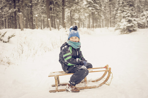 Germany, Bavaria, Berchtesgadener Land, happy boy on sledge stock photo