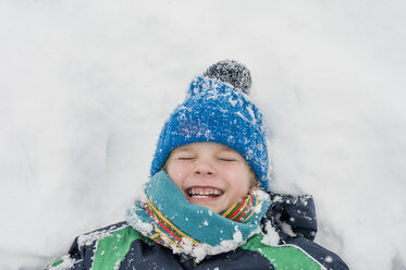 Germany, Bavaria, Berchtesgadener Land, happy boy lying in snow - MJF001429