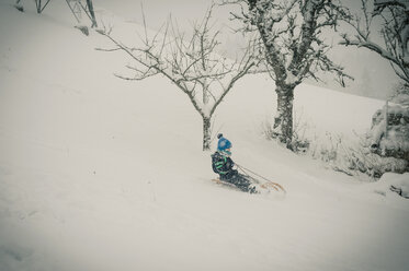 Germany, Bavaria, Berchtesgadener Land, boy tobogganing - MJF001430