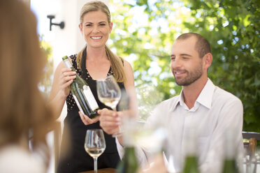 Woman presenting bottle of wine on a wine tasting session - ZEF003183