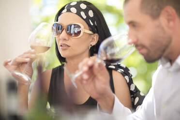 Man and woman examining red wine on a wine tasting session - ZEF003268