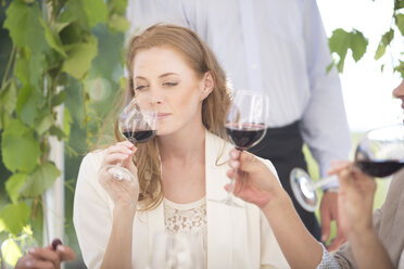 Woman smelling red wine on a wine tasting session - ZEF003202