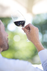 Man examining red wine on a wine tasting session - ZEF003216