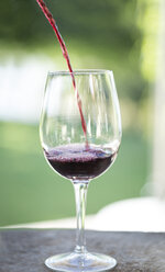 Rotwein wird in ein Glas gegossen - ZEF003219