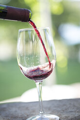 Rotwein wird in ein Glas gegossen - ZEF003220