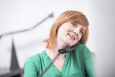 Lächelnde Geschäftsfrau am Telefon im Büro - ZEF003035