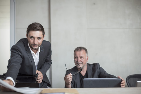 Zwei Geschäftsleute bereiten sich auf ein Treffen im Konferenzraum vor, lizenzfreies Stockfoto