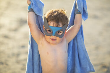 Kleiner Junge am Strand verkleidet als Superheld mit Maske und Handtuch - ZEF003410