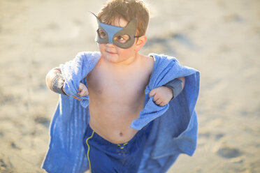 Kleiner Junge am Strand verkleidet als Superheld mit Maske und Handtuch - ZEF003411