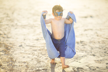 Kleiner Junge am Strand verkleidet als Superheld mit Maske und Handtuch - ZEF003413