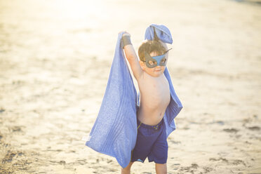Kleiner Junge am Strand verkleidet als Superheld mit Maske und Handtuch - ZEF003414