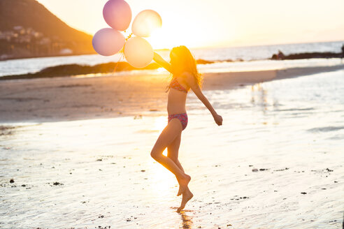 Mädchen am Strand mit Luftballons bei Sonnenuntergang - ZEF003322