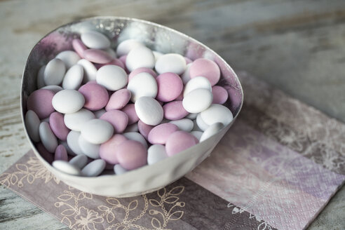 Schale mit weißen und rosa Schokoladenbohnen auf Papierserviette - SARF001214