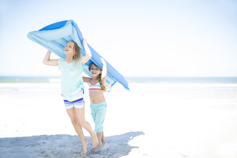 Zwei Mädchen am Strand mit einem Luftkissenboot, lizenzfreies Stockfoto