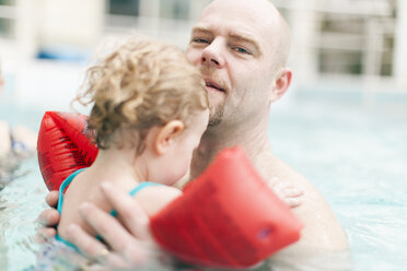 Father carrying little daughter in swimming pool - NNF000287