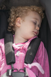 Kleines blondes Mädchen schläft im Autositz - NNF000311