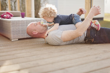 Father playing with little daughter on terrace - NNF000317