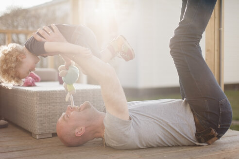 Vater spielt mit kleiner Tochter auf Terrasse - NNF000318