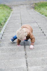 Little girl crawling up stairs - NNF000330