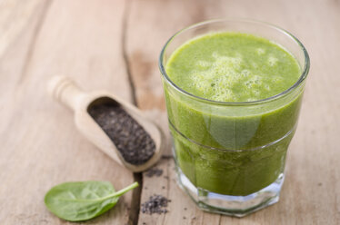 Glass of spinach smoothie, chia seeds and fresh spinach leave on wood - ODF001003