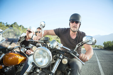 Friends riding motorcycles on open road - ZEF003576