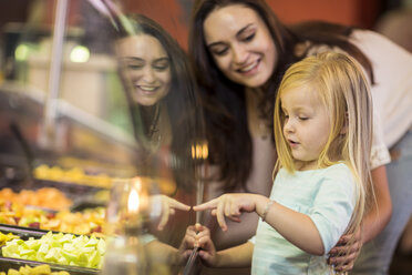 Mutter und Tochter betrachten einen Obstsalat im Supermarkt - ZEF004194