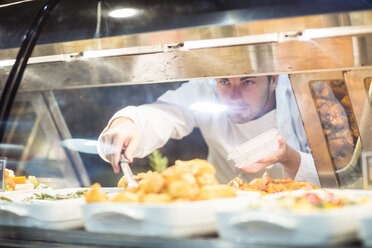 Shop assistant packing food from display at supermarket - ZEF004910